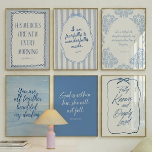 May include: Six framed art prints with inspirational quotes in blue and white. The prints feature various designs, including stripes, floral patterns, and decorative borders. The quotes are written in elegant script, offering a touch of faith and encouragement.