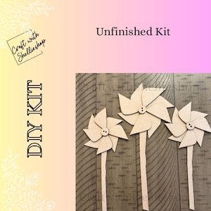 May include: Unfinished DIY kit featuring three wooden pinwheels with button centers and long stems. The text "DIY KIT" is printed vertically on the left, with "Unfinished Kit" at the top. The pinwheels are on a wooden surface.