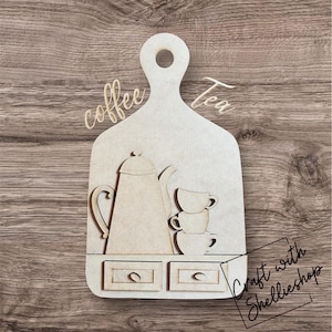 May include: Wooden cutout of a coffee and tea station with a coffee pot, two cups, and two drawers. The cutout is labeled "coffee" and "tea" and has the text "Craft with Shellieshop" at the bottom.