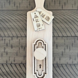 May include: Wooden cutting board with a cutout of a door knob and three wooden tags with the text "Ask and it shall be given you, Seek and you shall find, Knock and it shall be opened unto you, Matthew 7:7".