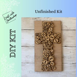 May include: DIY kit featuring a wooden cross design. The cross is adorned with various sizes of wooden buttons. The words "DIY KIT" and "Unfinished Kit" are visible. The background is a light wood grain.