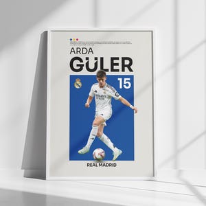 May include: A poster featuring a soccer player in a white jersey with the text "Arda Güler" and "Real Madrid" on a blue background.