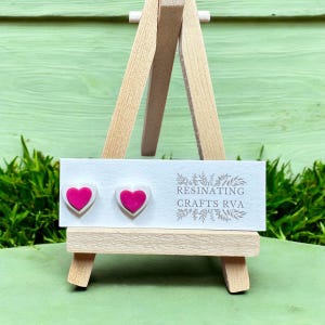 May include: A pair of pink and white heart-shaped resin earrings on a white card with the text "RESINATING CRAFTS RVA".