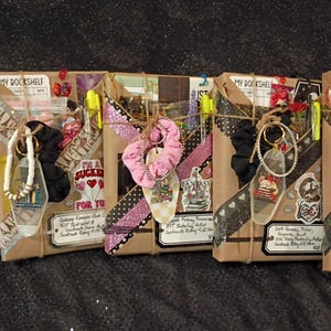 May include: Five rectangular packages wrapped in brown paper, each labeled My Bookshelf. Each package is decorated with patterned washi tape, stickers, a fabric scrunchie, a keychain, and a small tag with handwritten text, tied together with twine.