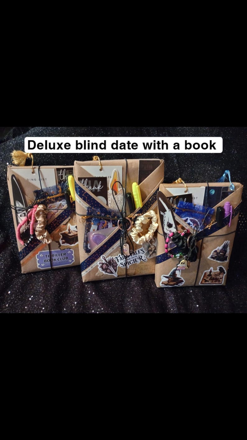 May include: Three books wrapped in brown paper, labeled Deluxe blind date with a book. Each package is tied with string and decorated with stickers, a scrunchie, a pen, and a small charm. The stickers feature various illustrations and text.