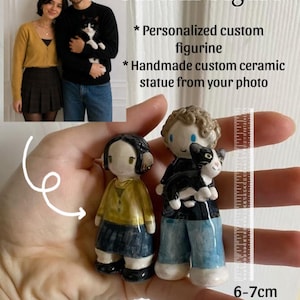 Puede incluir: Dos figuras de cerámica personalizadas, de unos 6-7 cm de altura, se sostienen en una mano. Una figura representa a una persona con camisa amarilla y falda azul, la otra a una persona que sostiene un gato blanco y negro. El texto dice "Custom Figure".
