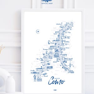 Può includere: Una stampa incorniciata con una mappa illustrata in blu e bianco del Lago di Como, Italia. La mappa include la forma del lago, i nomi delle città e i punti di riferimento. Il testo "LAGO DI Como" è scritto in corsivo. La parte superiore della cornice recita "the Larianer OFFICIAL SHOP".