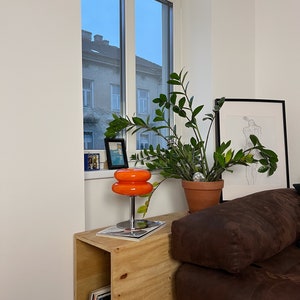 Marshmallow Tischlampe in Orange von GLOW UP STUDIO, stilvoll platziert neben einer Pflanze Esszimmer.