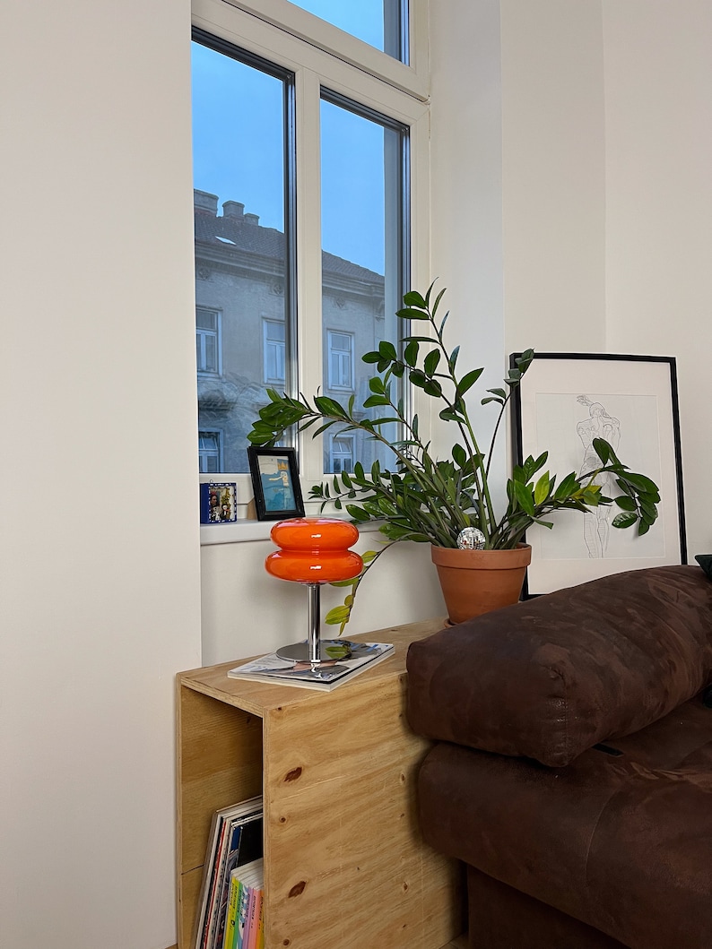 Marshmallow Tischlampe in Orange von GLOW UP STUDIO, stilvoll platziert neben einer Pflanze Esszimmer.