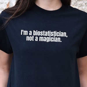 Puede incluir: Camiseta negra con texto blanco que dice "Soy bioestadístico, no mago."