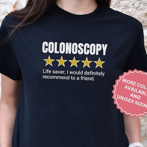 May include: Black t-shirt with the text "COLONOSCOPY" and five gold stars. The text "Life saver, I would definitely recommend to a friend." is below the stars. A red circle with the text "MORE COLORS AVAILABLE AND UNISEX SIZING" is in the bottom right corner.