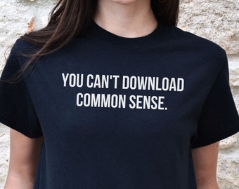 Puede incluir: Camiseta negra con texto blanco que dice "YOU CAN'T DOWNLOAD COMMON SENSE."