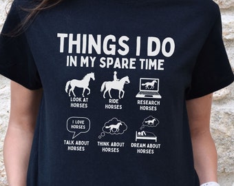 Könnte beinhalten: Ein schwarzes T-Shirt mit weißem Text, der "Things I do in my spare time" lautet und Aktivitäten auflistet, die mit Pferden zu tun haben, darunter das Betrachten von Pferden, Reiten, Recherchieren über Pferde, Reden über Pferde, Nachdenken über Pferde und Träumen von Pferden.