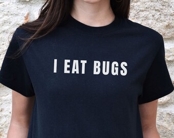 May include: A black t-shirt with the text "I EAT BUGS" printed in white on the front.