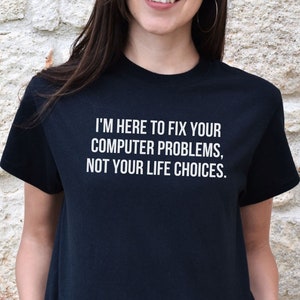 May include: A black t-shirt with white text that reads "I'm here to fix your computer problems, not your life choices."