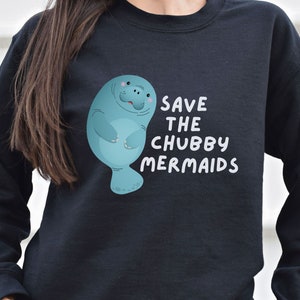 May include: Black sweatshirt with a blue manatee illustration and the text "Save the Chubby Mermaids".