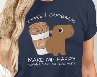 May include: A navy blue t-shirt with a cartoon capybara and a cup of coffee. The text on the shirt reads "Coffee & Capybaras Make Me Happy Humans Make My Head Hurt".