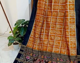 May include: A draped textile with a mustard yellow and white checkered pattern with repeating motifs. The border is black with a detailed, colourful design of birds, flowers, and other figures. The fabric is likely a saree.