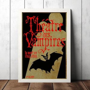 May include: Framed vintage poster with the text "Theatre des Vampires" in red gothic lettering. A black bat silhouette is featured against a tan background, with a black backdrop. The poster is in a white frame.