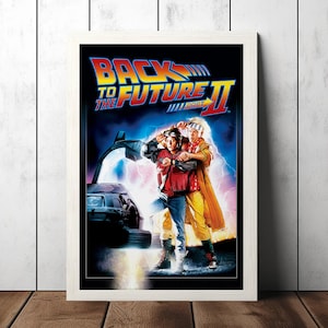 Peut inclure: Une affiche de film pour Retour vers le futur 2, mettant en scène Marty McFly et Doc Brown debout devant une DeLorean. L'affiche a un fond bleu et violet avec des éclairs et le texte "Retour vers le futur 2" en blanc.
