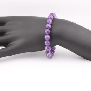 May include: A purple amethyst gemstone bracelet with round beads.