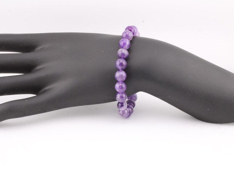 May include: A purple amethyst gemstone bracelet with round beads.