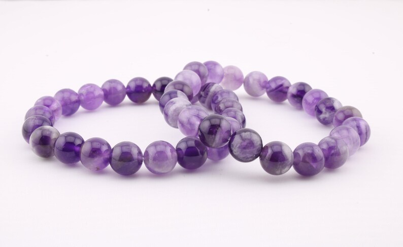 Chevron Amethyst bracelet featuring 8mm and 6mm natural gemstone beads. This women’s jewelry piece promotes calmness, spiritual growth, and intuition. A perfect gift for wellness seekers, offering unique purple and white banded patterns for healing
