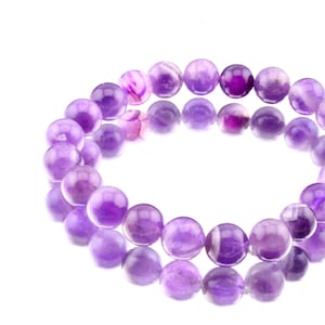 May include: A purple amethyst gemstone bracelet with round beads.