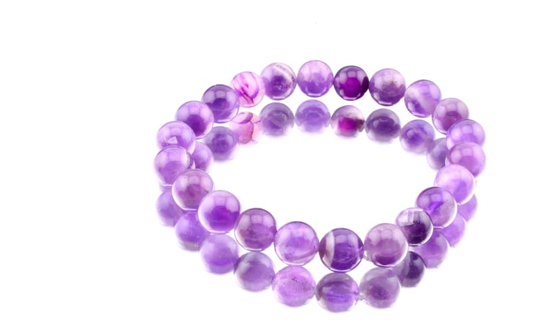 May include: A purple amethyst gemstone bracelet with round beads.