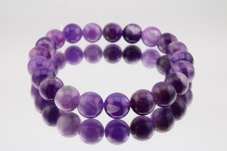 May include: A purple amethyst gemstone bracelet with round beads.