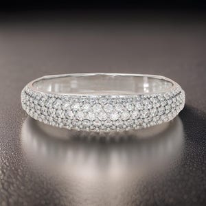 Könnte beinhalten: Ein silberner Bandring mit einer Pavé-Fassung aus kleinen Diamanten.
