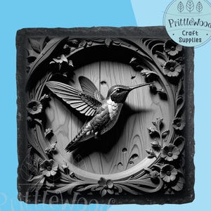 Puede incluir: Escultura en relieve de colibrí en blanco y negro. El colibrí está en vuelo, rodeado de tallas florales. La escultura está enmarcada en un marco cuadrado con el texto "Prittlewood Craft Supplies".