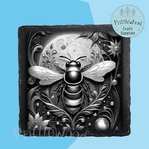 May include: Black and white illustration of a bee with intricate floral details on a black slate coaster. The bee is surrounded by swirling patterns and a moon in the background.