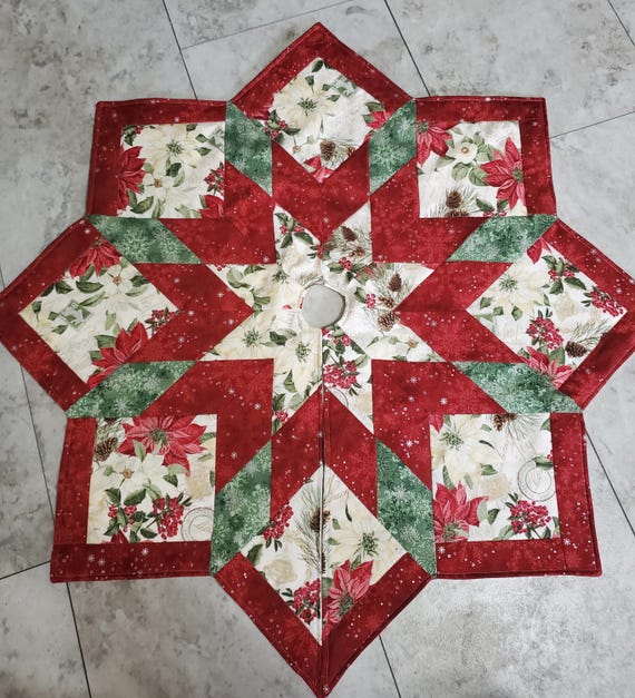 Cute little tabletop quilted tree skirt with poinsettias and silver snowflakes throughout on the front