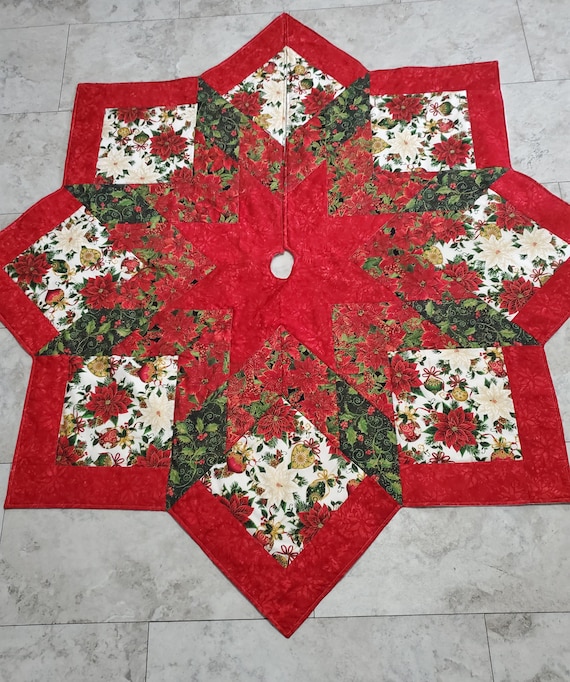 Beautiful bright, large, quilted Christmas tree skirt with decorative ornaments and poinsettias
