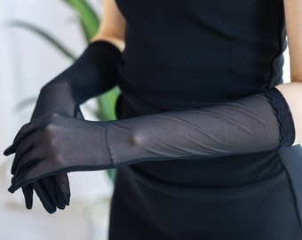 May include: A pair of long black sheer gloves with a scalloped edge. The gloves are made of a delicate, see-through fabric.