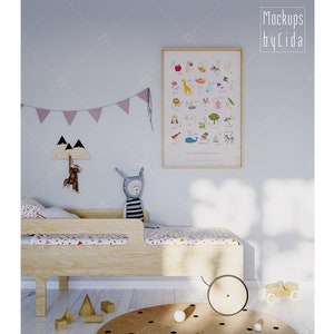 Könnte beinhalten: Eine hellblaue Wand mit einem Holzrahmen um ein farbenfrohes Alphabet-Poster. Das Poster zeigt Illustrationen von Tieren und Objekten für jeden Buchstaben des Alphabets. Im Vordergrund ein Holzbett mit einem weißen und rosa gemusterten Laken. Ein Stofftierhase sitzt auf dem Bett.