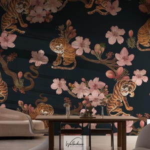 Puede incluir: Papel pintado de color verde azulado oscuro con un patrón repetido de tigres y flores de cerezo. Los tigres son de color naranja y negro, y las flores son rosas. El papel pintado crea un ambiente caprichoso y artístico.