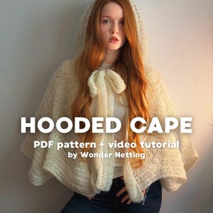 Puede incluir: Capa con capucha de color crema con cierre de lazo, hecha de un material texturizado de tejido abierto. El texto "HOODED CAPE" se muestra en letras blancas grandes, con información adicional sobre un patrón PDF y un tutorial en vídeo.
