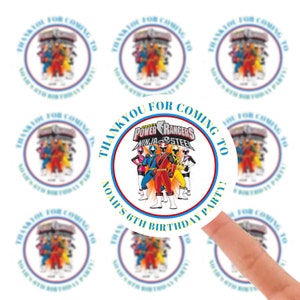 Op de afbeelding: Ronde, witte bedank stickers met een blauwe en rode rand. De stickers hebben een Power Rangers Ninja Steel logo en de tekst "Bedankt voor het komen naar Noah's 6e verjaardagsfeest!"