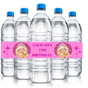 May include: Pink and white water bottle labels with a pink background and a circle with a cartoon image of a blonde girl with a crown. The text on the label reads "Aaliyah's 7th Birthday".