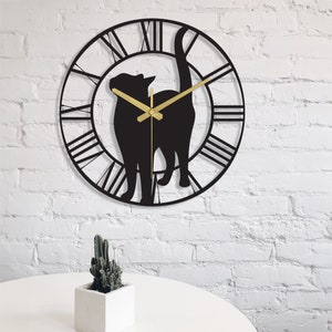 May include: Black metal wall clock with a silhouette of a cat and Roman numeral markings.