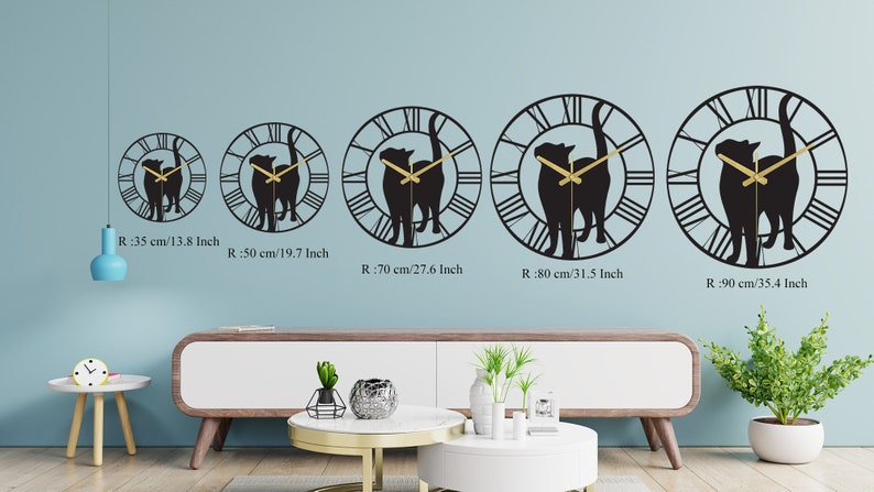 Puede incluir: Cinco relojes de pared de metal negro con n&uacute;meros romanos y una silueta de dos gatos. Los relojes se muestran en una pared azul claro con un borde blanco. Los relojes est&aacute;n disponibles en cinco tama&ntilde;os: 35 cm, 50 cm, 70 cm, 80 cm y 90 cm.