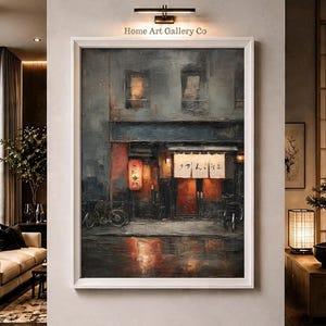 May include: A framed oil painting depicting a dark, rainy street scene at night with a storefront featuring a red lantern and a white noren curtain with Japanese text. The artwork is displayed on a wall under a light fixture labeled Home Art Gallery Co.
