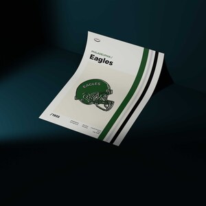 May include: A minimalist poster with a green and white color scheme featuring the Philadelphia Eagles logo. The logo is a green football helmet with the word "Eagles" written on the side. The poster has the text "Philadelphia/Eagles" at the top and the number "19X3" at the bottom.