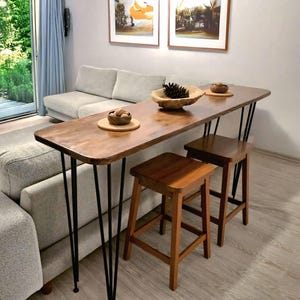 Può includere: Un cartello in legno rustico con la scritta "Welcome to our home" in stile scritto a mano. Il cartello è rettangolare, con una finitura invecchiata e un design semplice e accogliente.