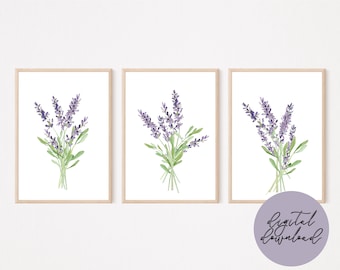 Könnte beinhalten: Drei gerahmte Aquarelldrucke von Lavendelsträußen. Jeder Druck zeigt ein Bündel lila Lavendelblüten mit grünen Blättern vor weißem Hintergrund. Die Rahmen sind hellholzfarben. Das Bild enthält eine Grafik zum digitalen Download.
