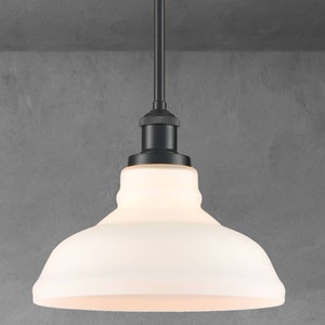 May include: A black pendant light with a white frosted glass shade. The shade is round and has a slight curve at the top.