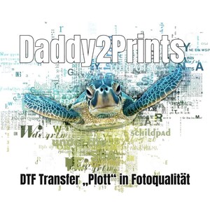 Könnte beinhalten: Eine grüne Meeresschildkröte mit einem blauen Panzer schwimmt durch eine Collage aus Zeitungstext. Der Text enthält die Wörter "Daddy2Prints", "DTF Transfer" und "Plott" in Fotoqualität.