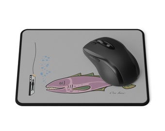 Könnte beinhalten: Eine graue Mausmatte mit einer Cartoon-Illustration eines lila Fisches mit grünen Flossen und einem schwarzen Telefon mit einer Person auf dem Bildschirm. Der Text "On line" steht unter dem Fisch.